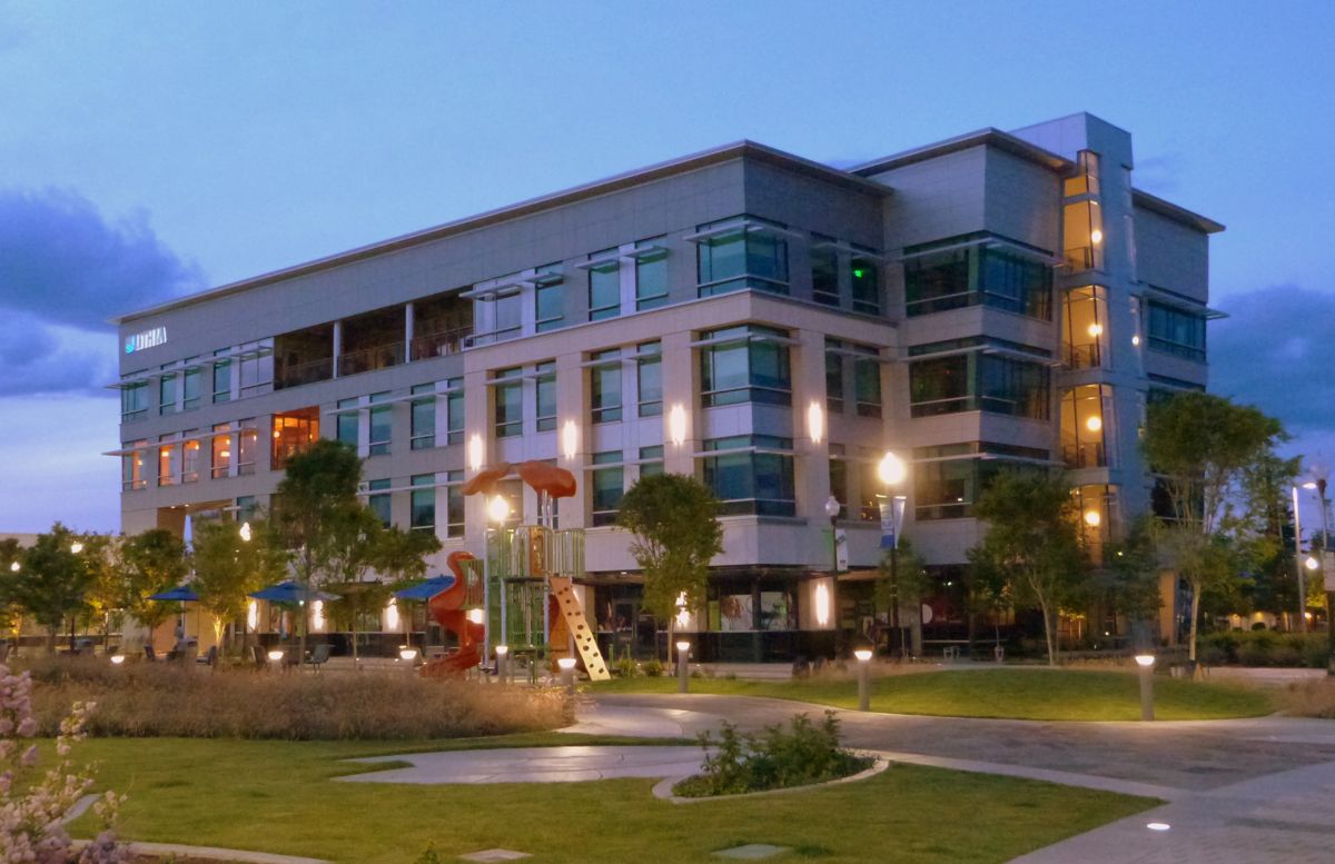 The Commons park and playground in downtown Medford at dusk with lit buildings behind